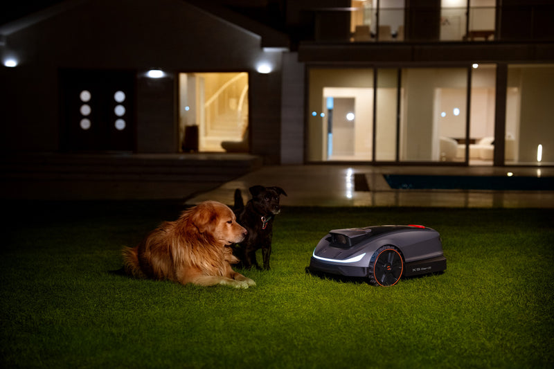 Sunseeker Elite X5 Gen 2 robotic lawn mower, mowing at night with headlights on