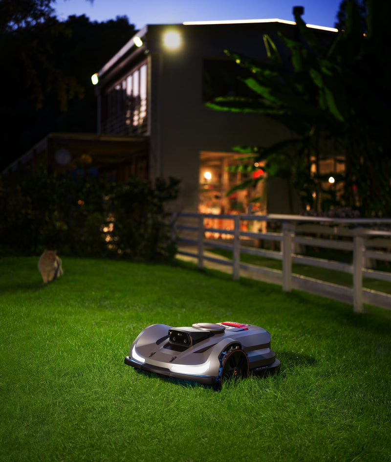 Sunseeker Elite X7 Gen 2 robotic lawn mower, mowing at night with headlights on